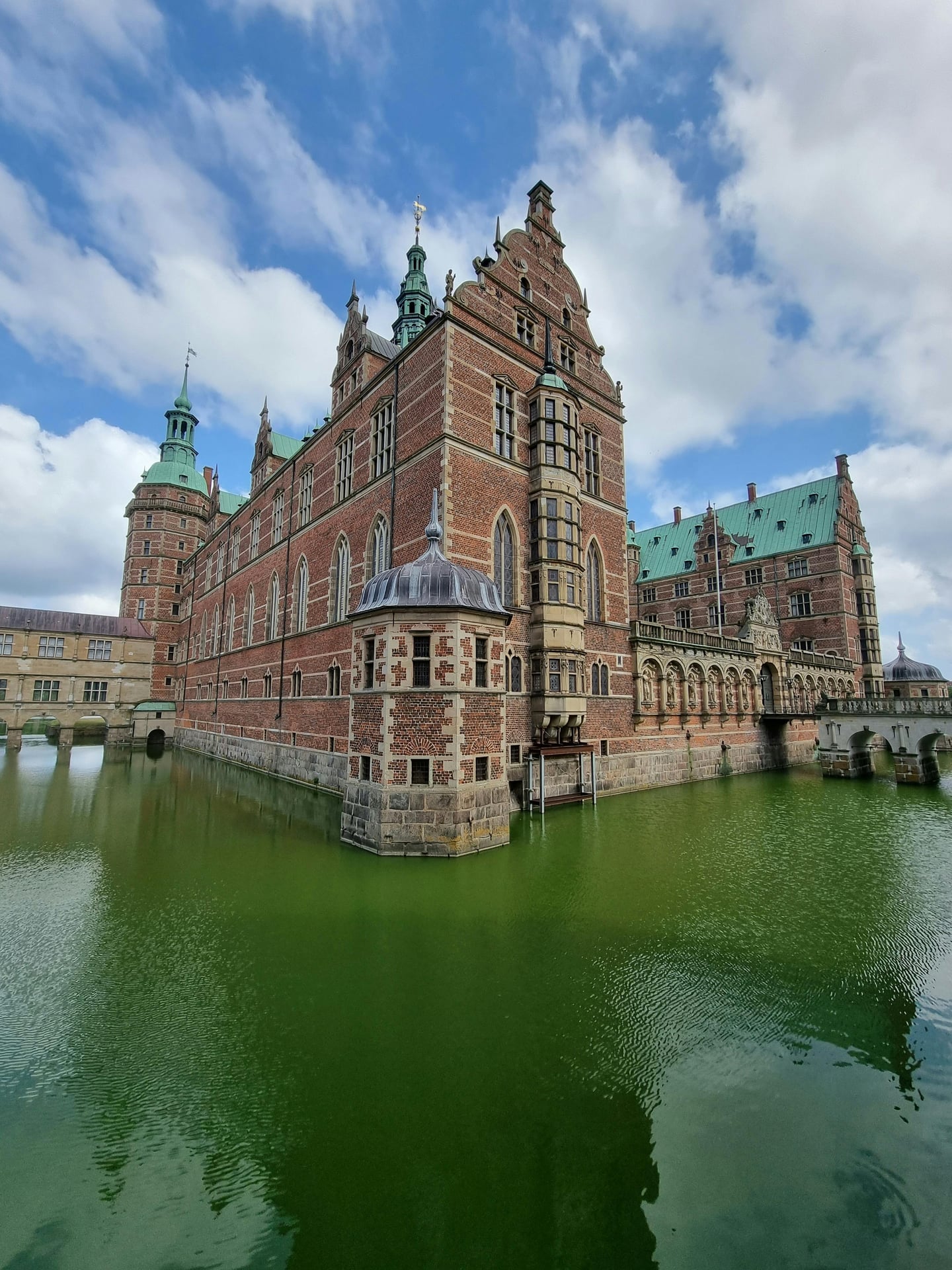 힐레뢰드 프레데릭스보르 성, 푸른 호수 위에 솟아오른 붉은 벽돌 성벽과 화려한 청동 첨탑이 조화를 이루는 덴마크의 웅장한 르네상스 건축물입니다.