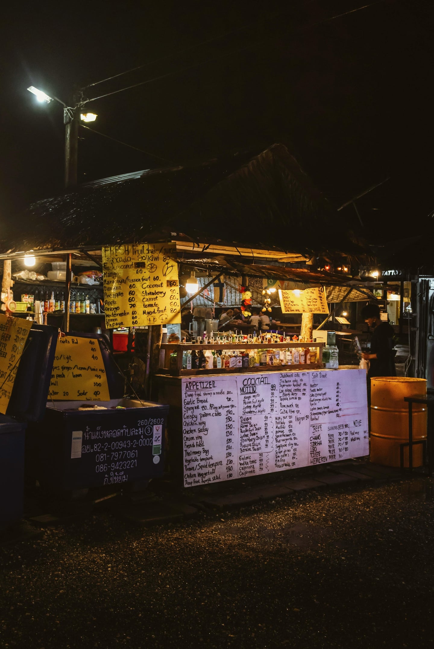 푸켓 카오락 야시장, 밤거리를 밝히는 노점 바의 화려한 칵테일 메뉴판과 이국적인 가판대 풍경입니다.
