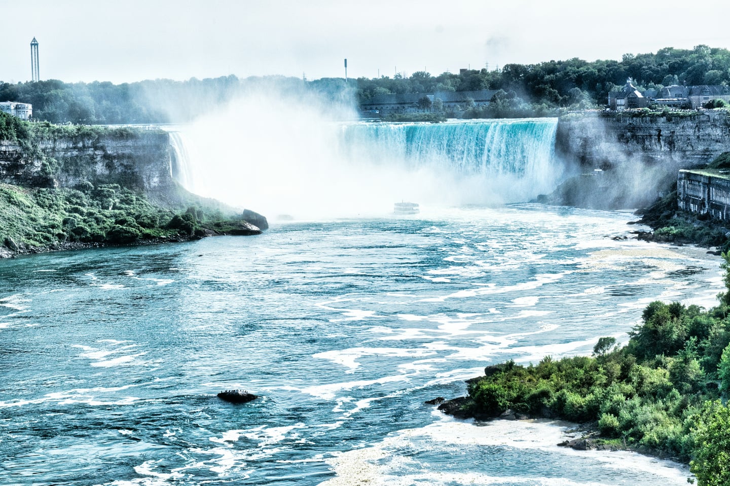 나이아가라 나이아가라 폭포, 거대한 물줄기가 쏟아지며 피어오르는 하얀 물안개와 푸른 강물이 어우러진 웅장한 자연 경관입니다.