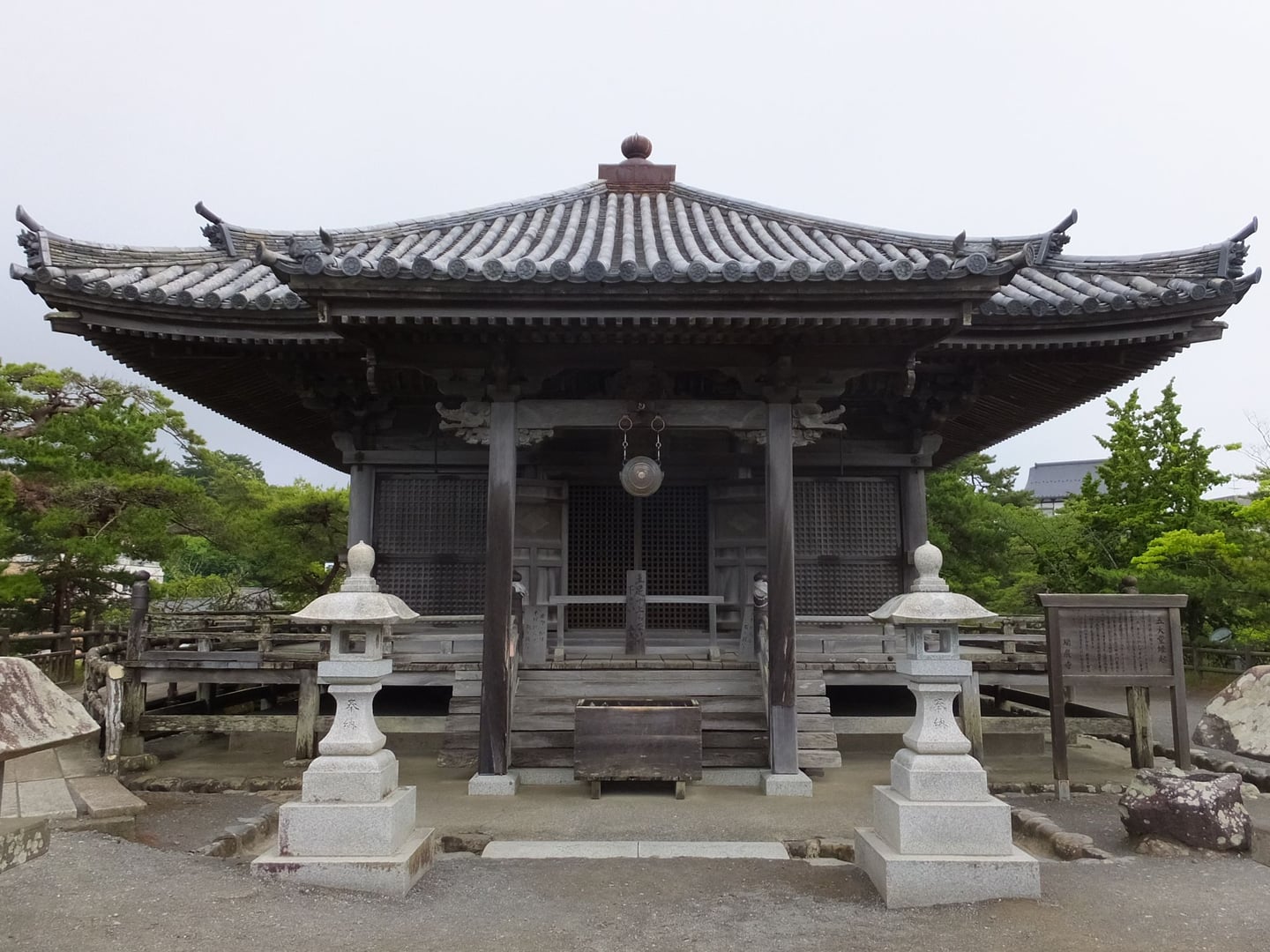 센다이 고다이도, 고풍스러운 목조 건축 양식이 돋보이는 사당 정면과 그 앞을 밝히는 좌우 대칭의 석등 및 주변 나무들이 조화롭게 어우러진 고즈넉한 사찰 전경의 풍경.