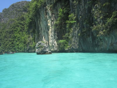 푸켓 피피섬, 에메랄드빛 투명한 바다와 웅장한 석회암 절벽이 어우러져 신비롭고 평화로운 열대 낙원의 풍경을 보여줍니다.