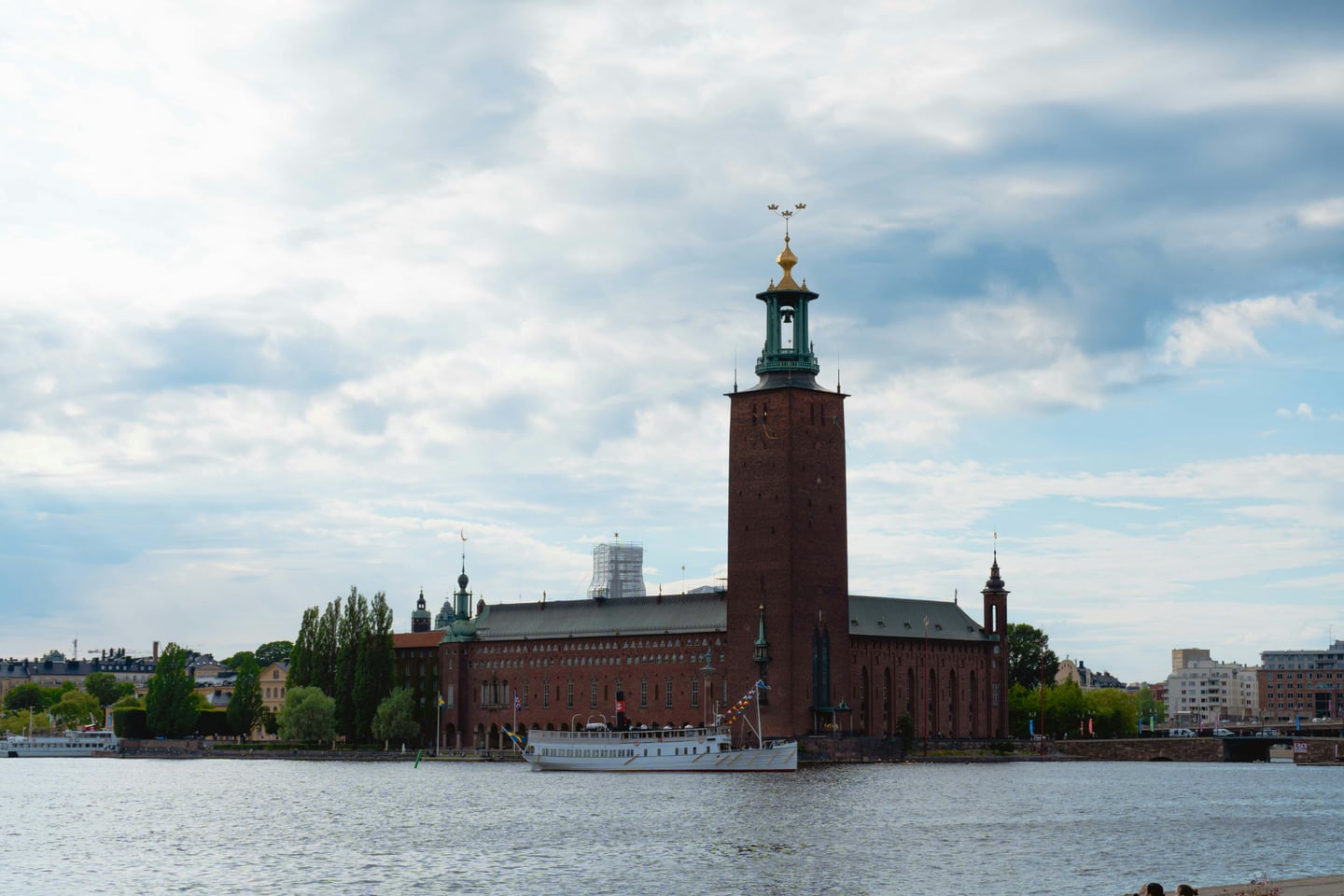 스톡홀름 스톡홀름 시청, 멜라렌 호수 위에 우뚝 솟은 붉은 벽돌의 시청사 건물과 세 개의 왕관이 장식된 높은 탑의 전경입니다.