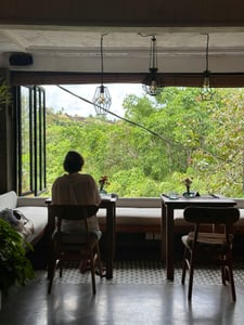 발리 우붓 티스 카페, 울창한 열대 정글이 한눈에 들어오는 창가 좌석에서 여유로운 시간을 보내는 뒷모습입니다.
