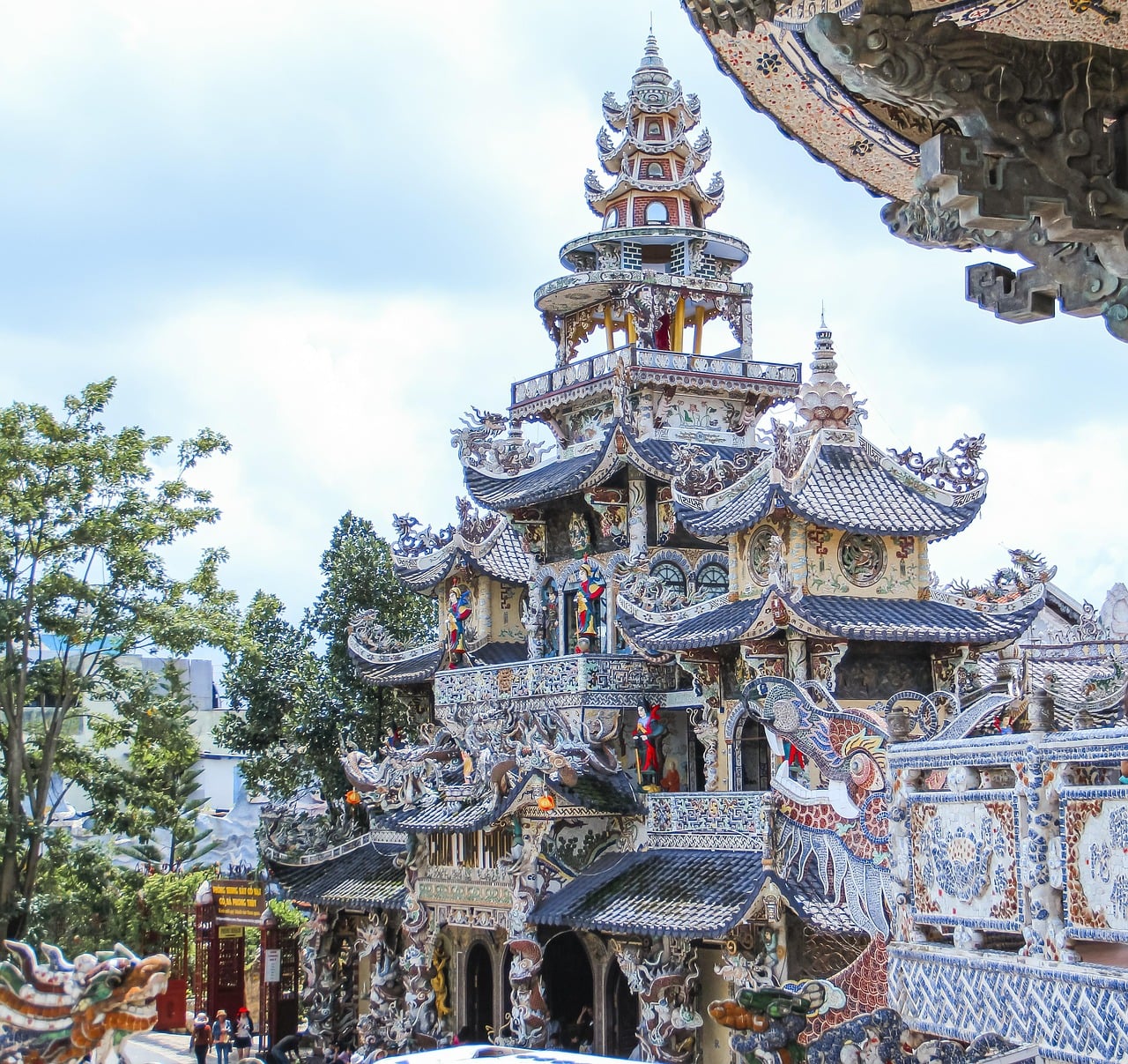 달랏 린푸옥 사원, 깨진 도자기 조각으로 장식된 화려한 모자이크 외벽과 정교한 용 조각상이 돋보이는 사원의 전경입니다.