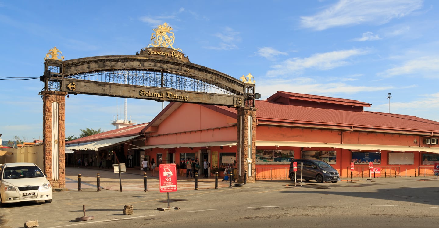 코타키나발루 제셜턴 포인트, 고풍스러운 아치형 입구와 붉은 지붕의 매표소 건물이 맑은 하늘 아래 펼쳐진 모습입니다.