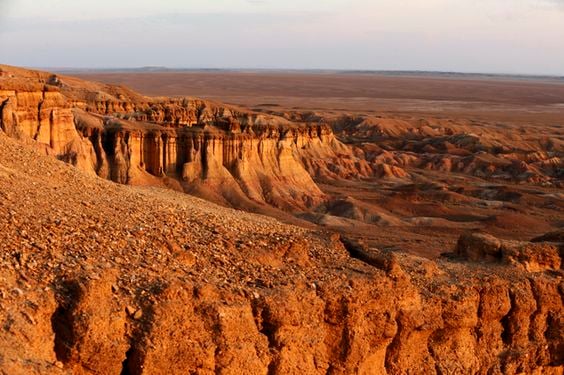 차강소보르가 차강소브라가, 붉은빛 석회암 절벽이 겹겹이 층을 이루며 광활한 고비 사막의 지평선과 어우러진 신비로운 풍경입니다.