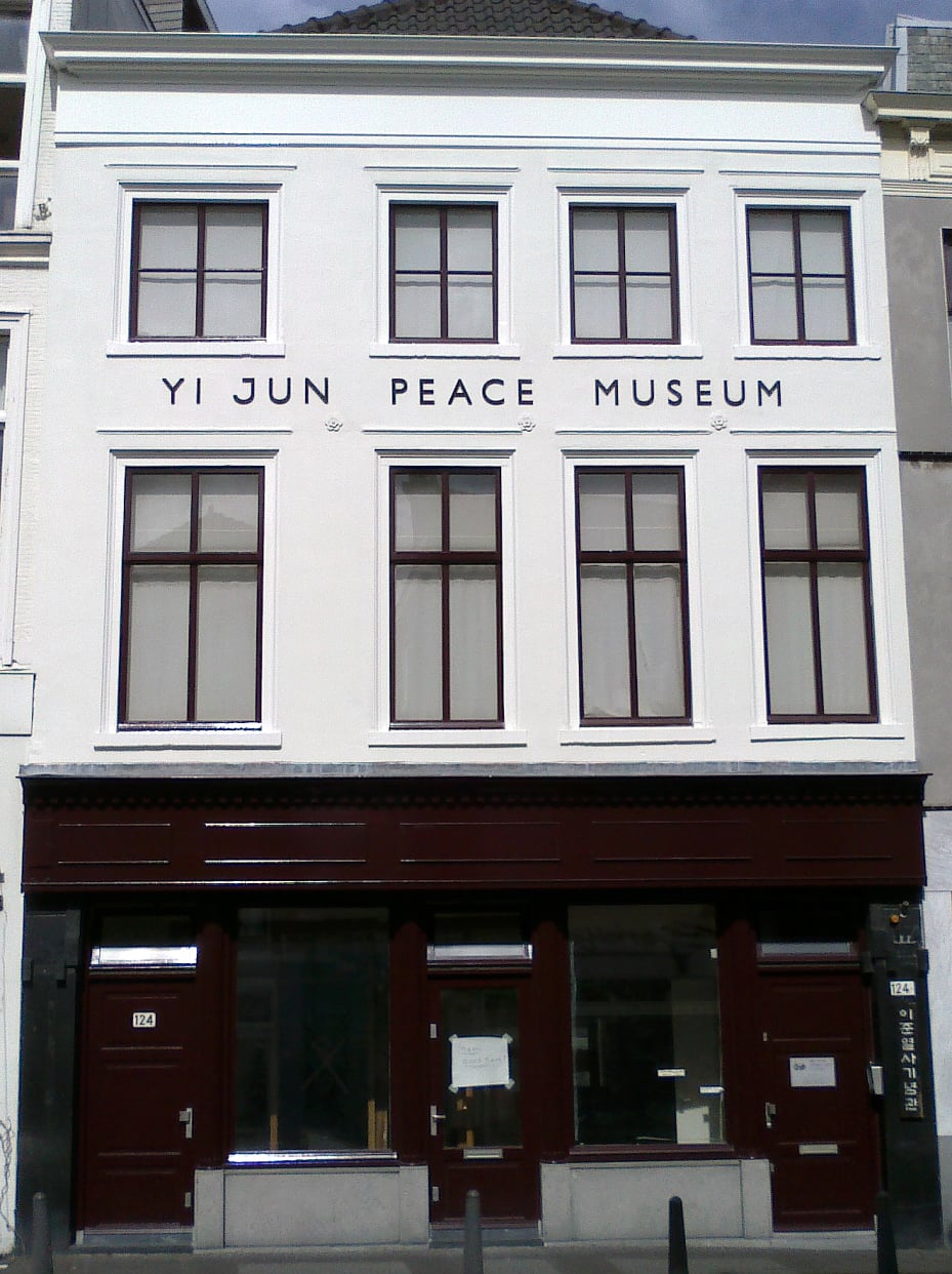 헤이그 이준 열사 기념관, 흰색 외벽에 영문 박물관 명칭과 한글 현판이 선명하게 보이는 역사적인 건물 정면 모습입니다.