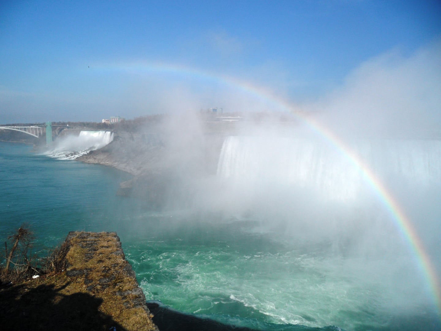나이아가라 나이아가라 파크웨이, 거대한 폭포의 물안개 사이로 선명하게 피어오른 무지개와 에메랄드빛 강물이 어우러진 장관입니다.