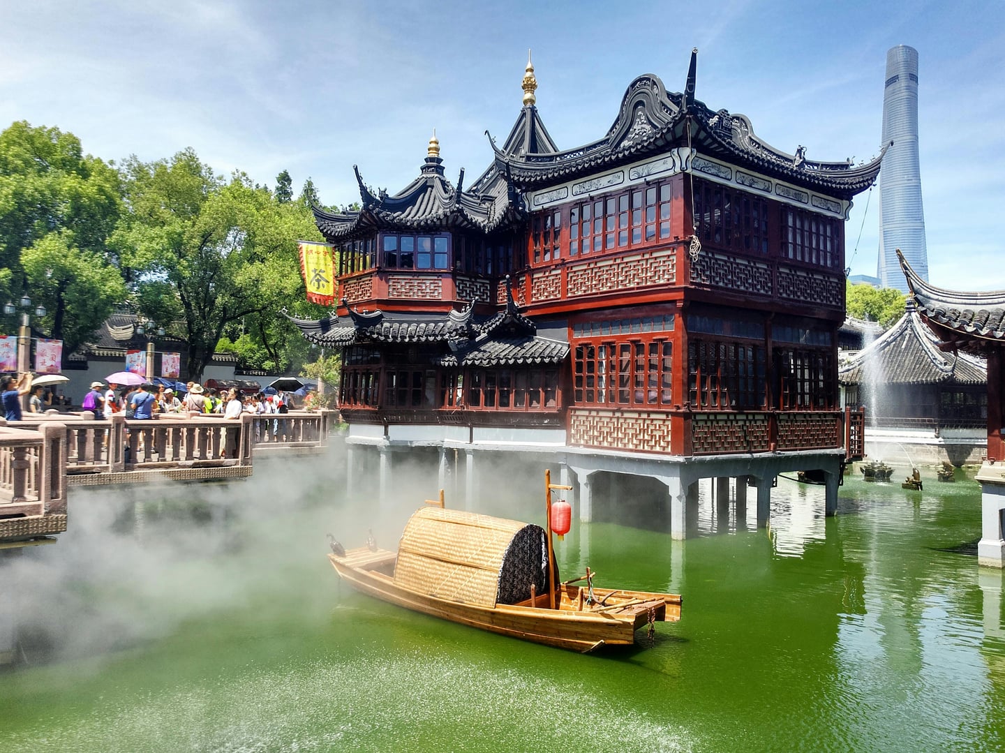 상하이 나룻배 유람, 예원 호심정의 고풍스러운 목조 건물과 물안개 낀 연못 위를 유유히 떠다니는 전통 나룻배의 평화로운 전경입니다.