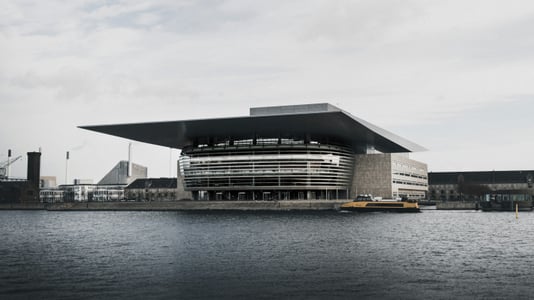 코펜하겐 왕립 오페라 하우스, 운하 위에 떠 있는 듯한 거대한 지붕과 유리 외관이 돋보이는 현대적인 건축물의 전경입니다.