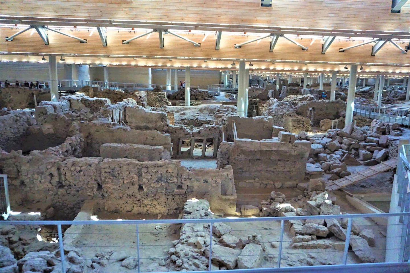 산토리니 아크로티리 유적, 거대한 보호 지붕 아래 보존된 고대 도시의 석조 벽면과 발굴 현장이 펼쳐진 모습입니다.