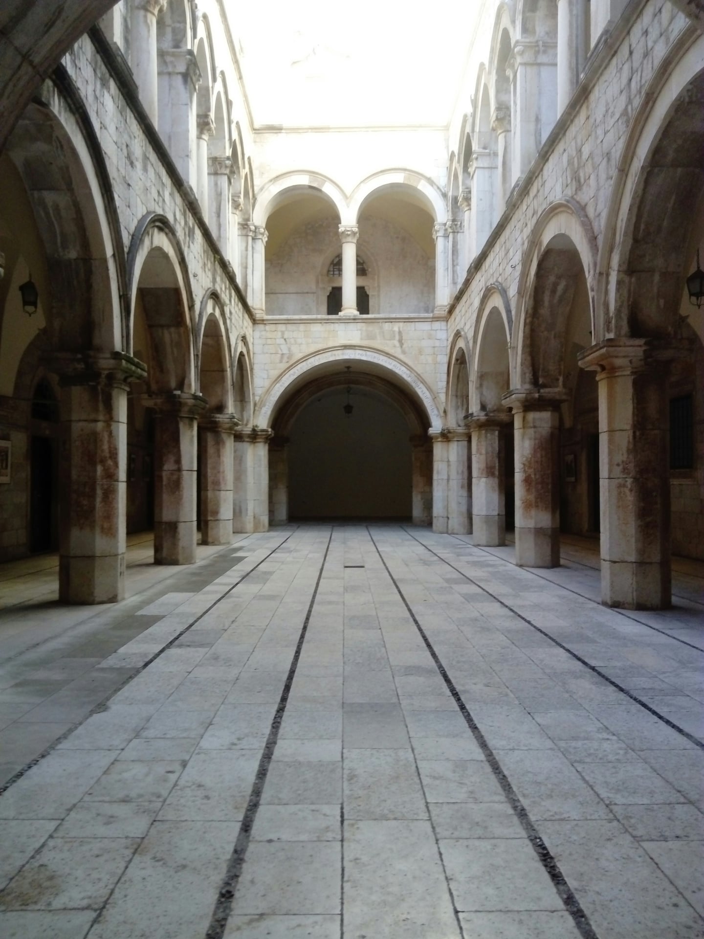 두브로브니크 스폰자 궁, 고딕과 르네상스 양식이 조화를 이룬 우아한 아치형 회랑과 대칭적인 석조 기둥이 돋보이는 내부 중정의 전경입니다.