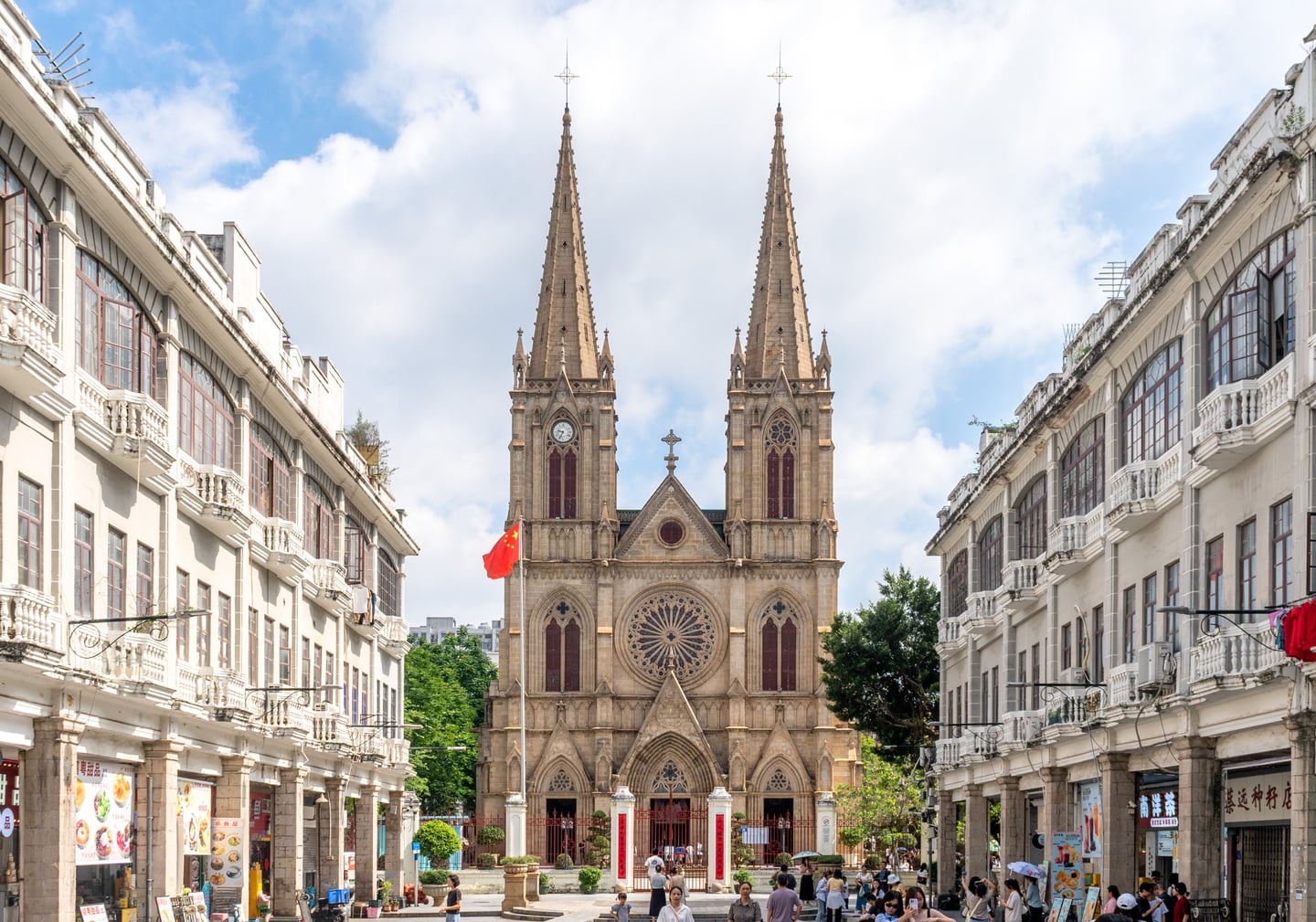 광저우 성심대성당, 푸른 하늘 아래 우뚝 솟은 고딕 양식의 쌍둥이 첨탑과 정교한 석조 외관이 돋보이는 웅장한 풍경입니다.