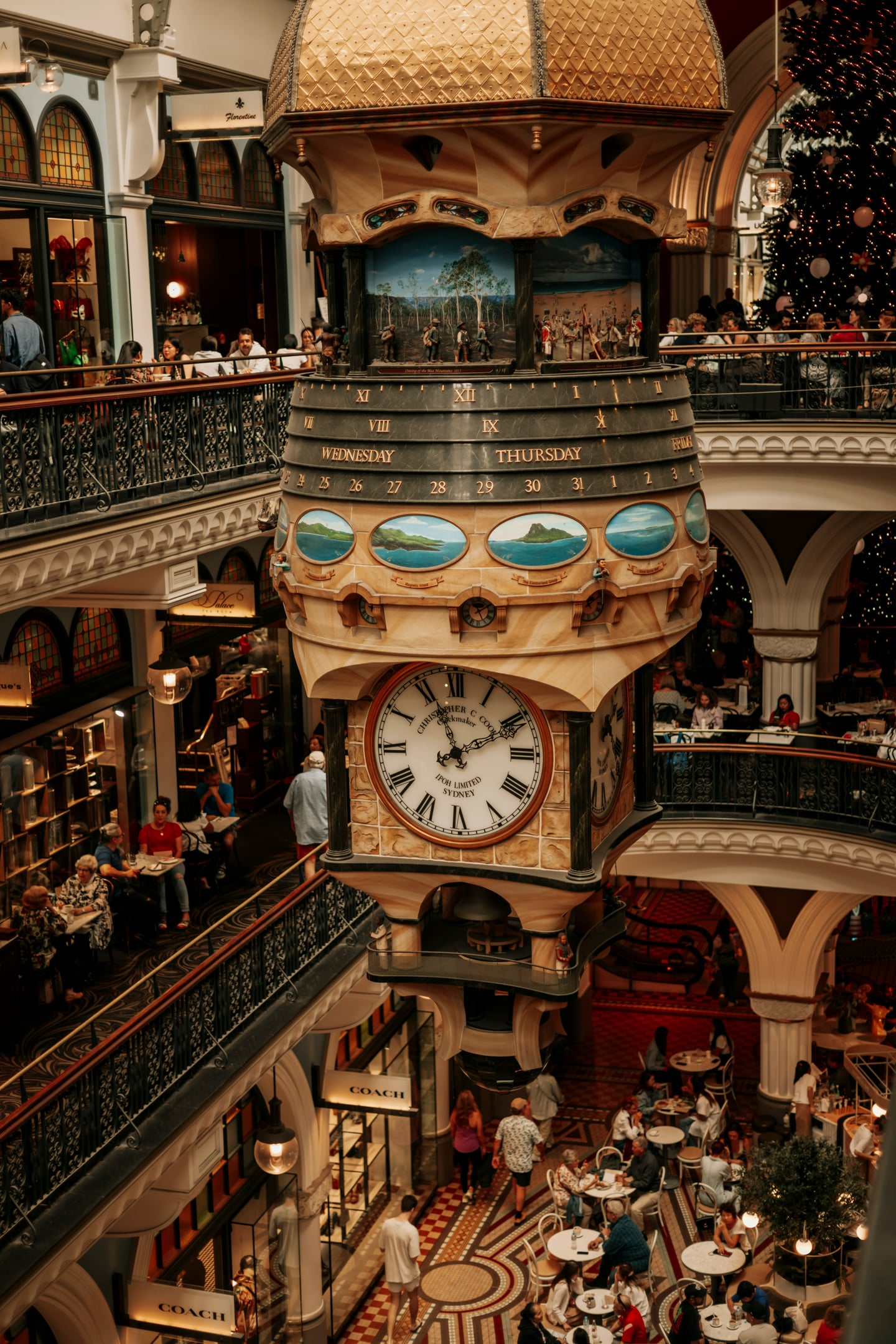 시드니 퀸 빅토리아 빌딩, 화려한 금빛 장식의 대형 시계와 고풍스러운 쇼핑몰 내부가 어우러진 웅장한 모습입니다.