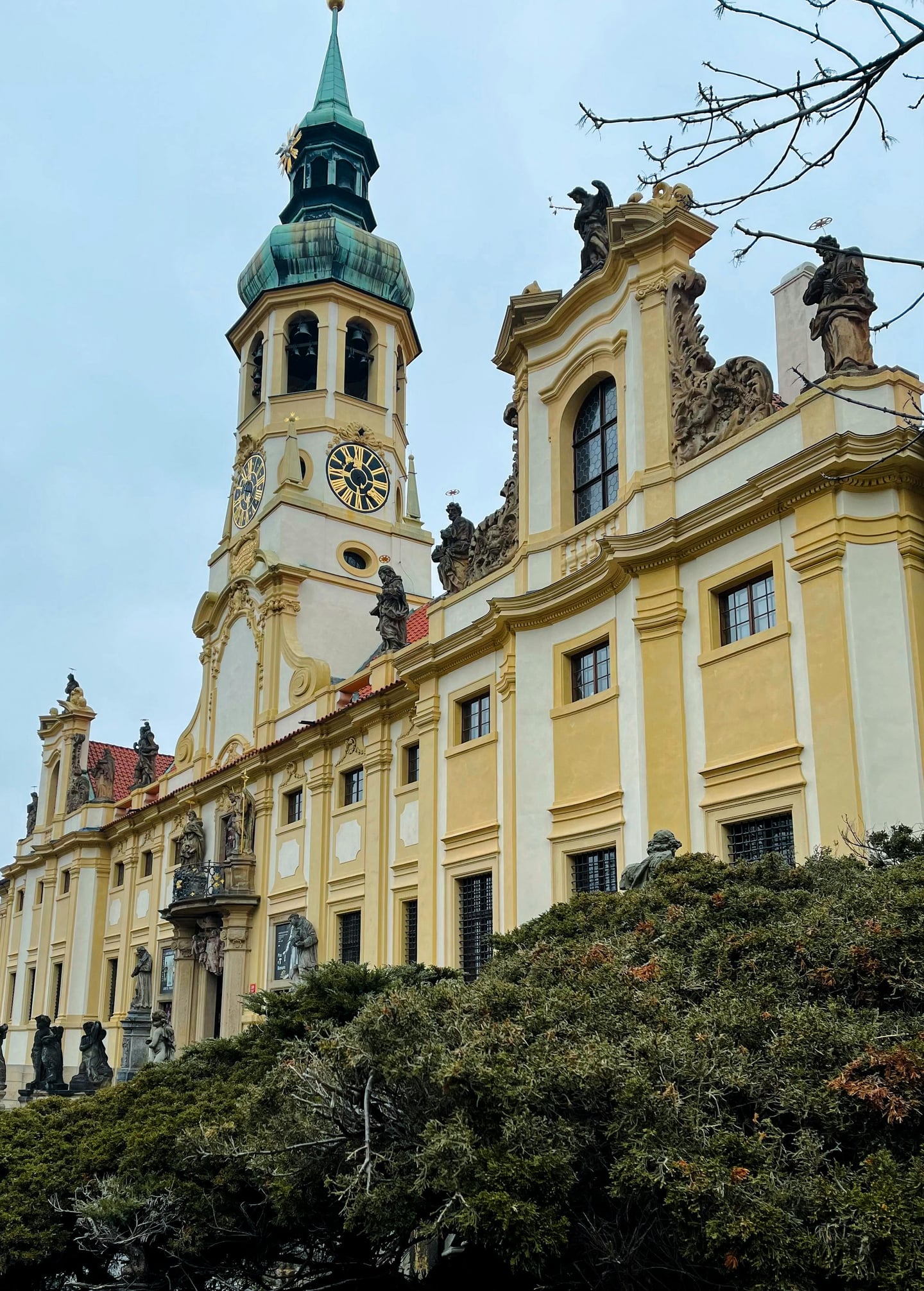 프라하 로레타 성당, 화려한 바로크 양식의 외관과 정교한 조각상이 장식된 시계탑이 돋보이는 역사적인 건축물입니다.