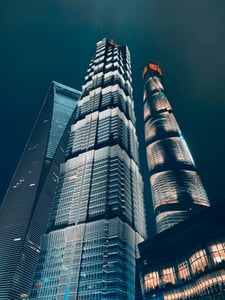 상하이 진마오 타워, 밤하늘을 배경으로 화려한 조명이 빛나는 초고층 빌딩들의 웅장한 수직적 야경 모습입니다.